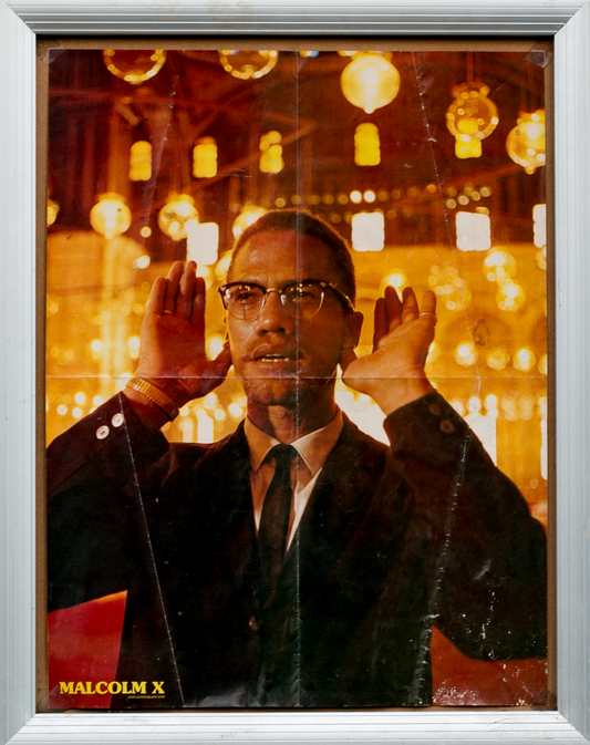 Amber toned photograph of Malcom X praying